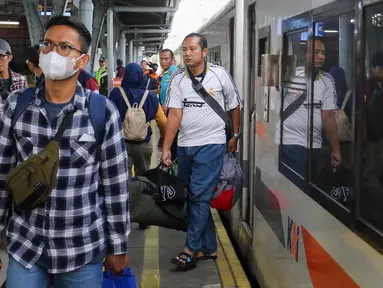 Penumpang Kereta Api Jarak Jauh (KAJJ) berjalan setibanya di Stasiun Pasar Senen, Jakarta, Sabtu (5/4/2025). (Liputan6.com/Herman Zakharia)