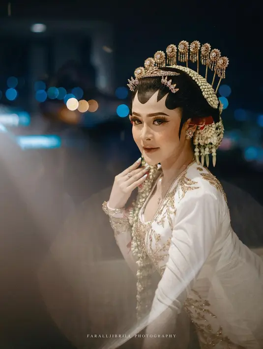 Bella yang jadi ratu sehari di momen bahagia tersebut tampil ayu mengenakan kebaya model kutubaru yang menjuntai sampai ke mata kaki dari Asri Leksono.