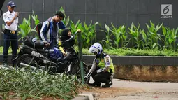 Petugas kepolisian menggembosi ban motor yang parkir di trotoar Jalan Kebon Sirih, Jakarta, Senin (17/7). Hal ini tindak lanjut maraknya pelanggaran lalu lintas di kawasan pedestrian Jalan Kebon Sirih. (Liputan6.com/Helmi Fithriansyah)