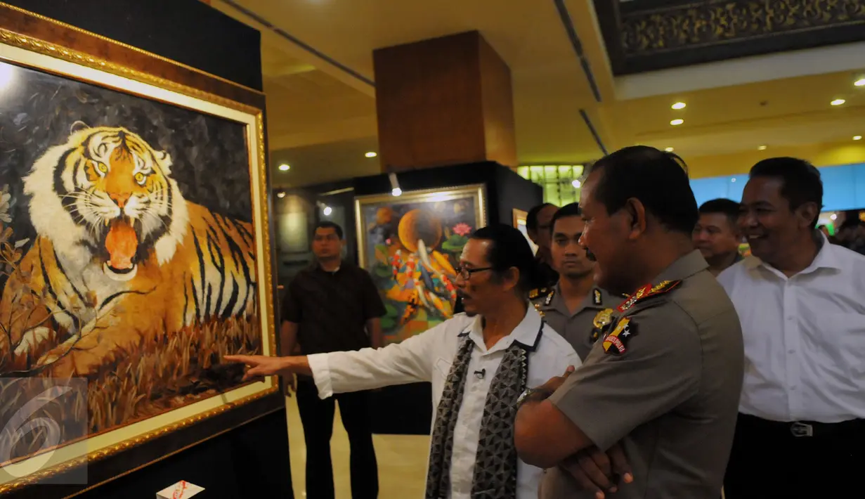 Kapolri Jenderal Badrodin Haiti menyimak penjelasan Pelukis Cak Kandar di Hotel Sultan Jakarta, Senin (21/3/2016). Kehadiran Kapolri Badrodin Haiti untuk meresmikan Pameran Lukisan Dua Tanda. (Liputan6.com/Faisal R Syam)