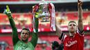 Penjaga gawang Arsenal, Lukasz Fabianski (kiri) bersama Per Mertesacker mengangkat trofi Piala FA usai menumbangkan Hull City 3-2 di Stadion Wembley, London, (18/5/2014). (REUTERS/Darren Staples)