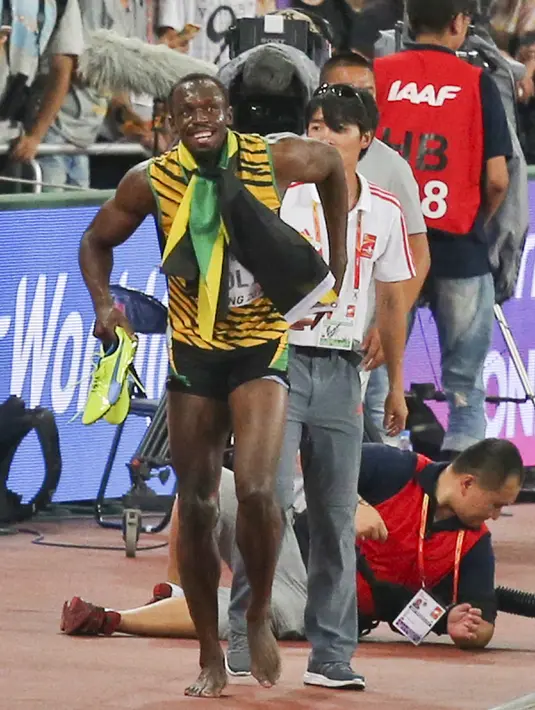 Pelari Jamaika, Usain Bolt melanjutkan selebrasi kemenanganya di nomor 200 meter pada Kejuaran Dunia Atletik usai terjatuh tertabrak kameramen yang mengendarai skuter di Beijing, Kamis (27/8). (REUTERS/Stringer CHINA OUT)