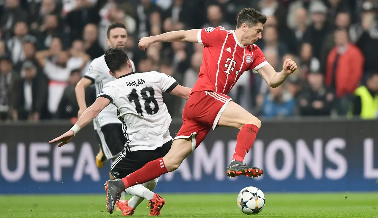 Robert Lewandowski (kanan) mencoba melewati adangan pemain Besiktas, Tolgay Arslan pada leg kedua 16 besar Liga Champions di Vodafone Stadyumu, Besiktas Park, Istanbul, (14/3/2018). Bayern menang 3-1. (AFP/Ozan Kose)