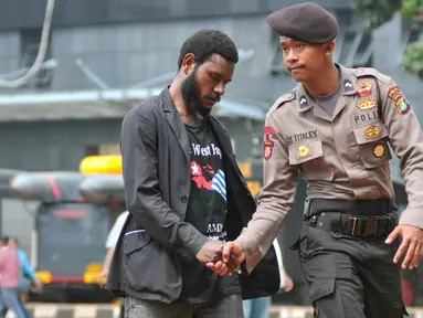 Mahasiswa Papua berjabat tangan dengan seorang polisi saat mendatangi Polda Metro Jaya, Jakarta, Selasa (1/12/2015). Kedatangan mereka untuk menunggu teman mereka yang diperiksa polisi (Liputan6.com/Yoppy Renato)