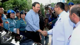 Cagub DKI Jakarta 2017 Basuki Tjahaja Purnama berjabat tangan dengan tim dokter saat akan menjalani tes kesehatan di RSAL Dr. Mintoharjo, Jakarta, Sabtu (24/9). Ahok tiba dengan mengenakan kemeja kotak-kotak berwarna biru. (Liputan6.com/Gempur M Surya). 