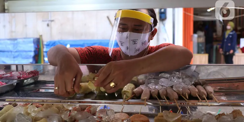 FOTO: Cegah Corona, Pedagang Ini Pakai Pelindung Wajah Saat Berjualan