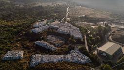 Pulau Corfu berada di Laut Ionia, Yunani, menghadapi masalah pengelolaan sampah. Hal ini dikarenakan, pemerintah kota hanya memiliki satu tempat pembuangan sampah yang mulai penuh. Tampak sebuah foto udara memperlihatkan ratusan bal-bal sampah yang dibungkus plastik disimpan di samping pabrik daur ulang di kota Pulau Corfu pada tanggal 15 Oktober 2025. (Angelos TZORTZINIS/AFP)
