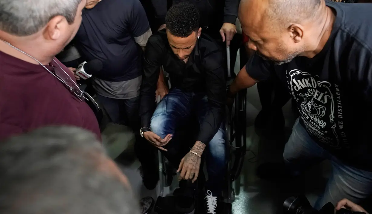 Bintang timnas Brasil, Neymar menggunakan kursi roda mendatangi kantor polisi di Rio de Janeiro, Kamis (6/6/2019). Kedatangan Neymar untuk memberikan keterangan karena menyebarkan foto dan percakapan pribadi dengan perempuan yang menudingnya melakukan pemerkosaan ke media sosial. (AP/Leo Correa)
