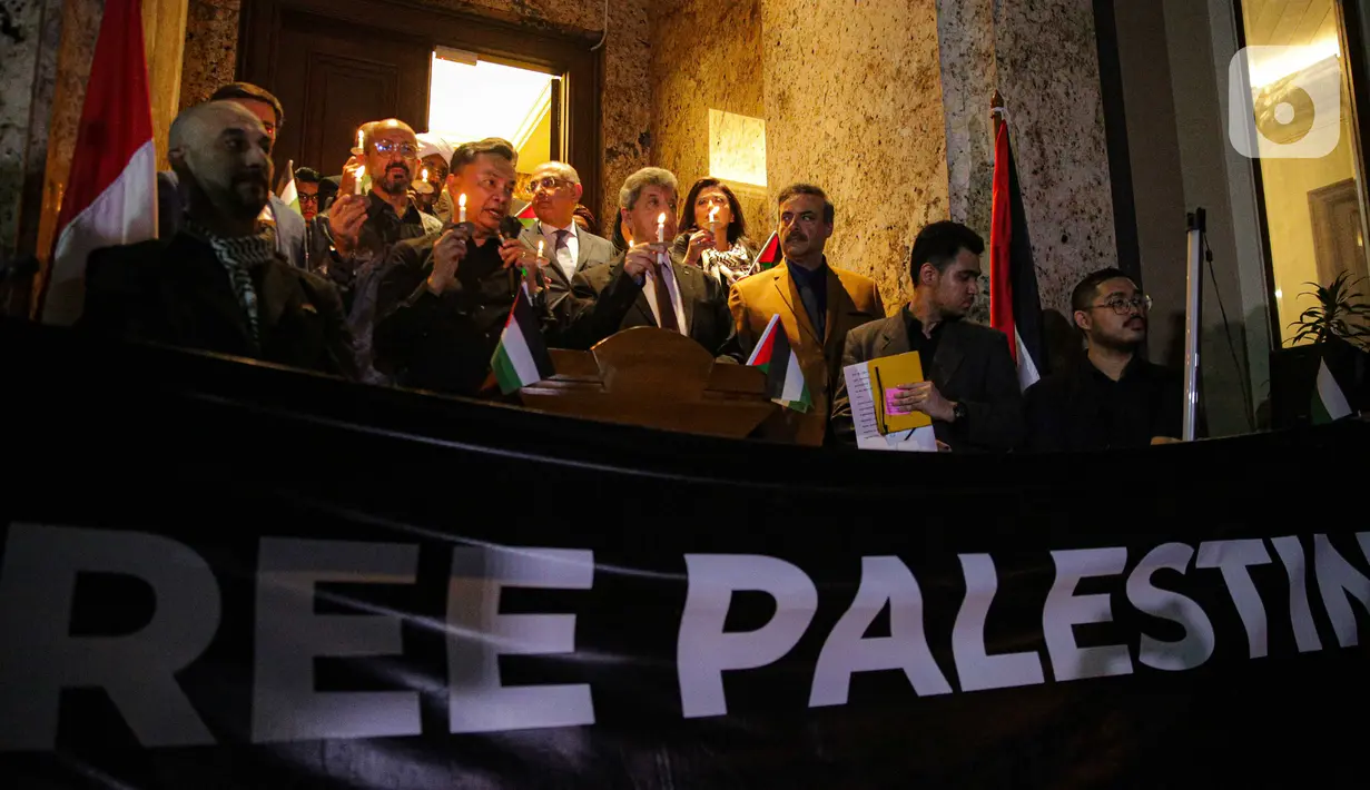 Massa menyalakan lilin sambil membawa bendera dan poster- poster bertuliskan pesan dukungan untuk rakyat Palestina. (Liputan6.com/Faizal Fanani)