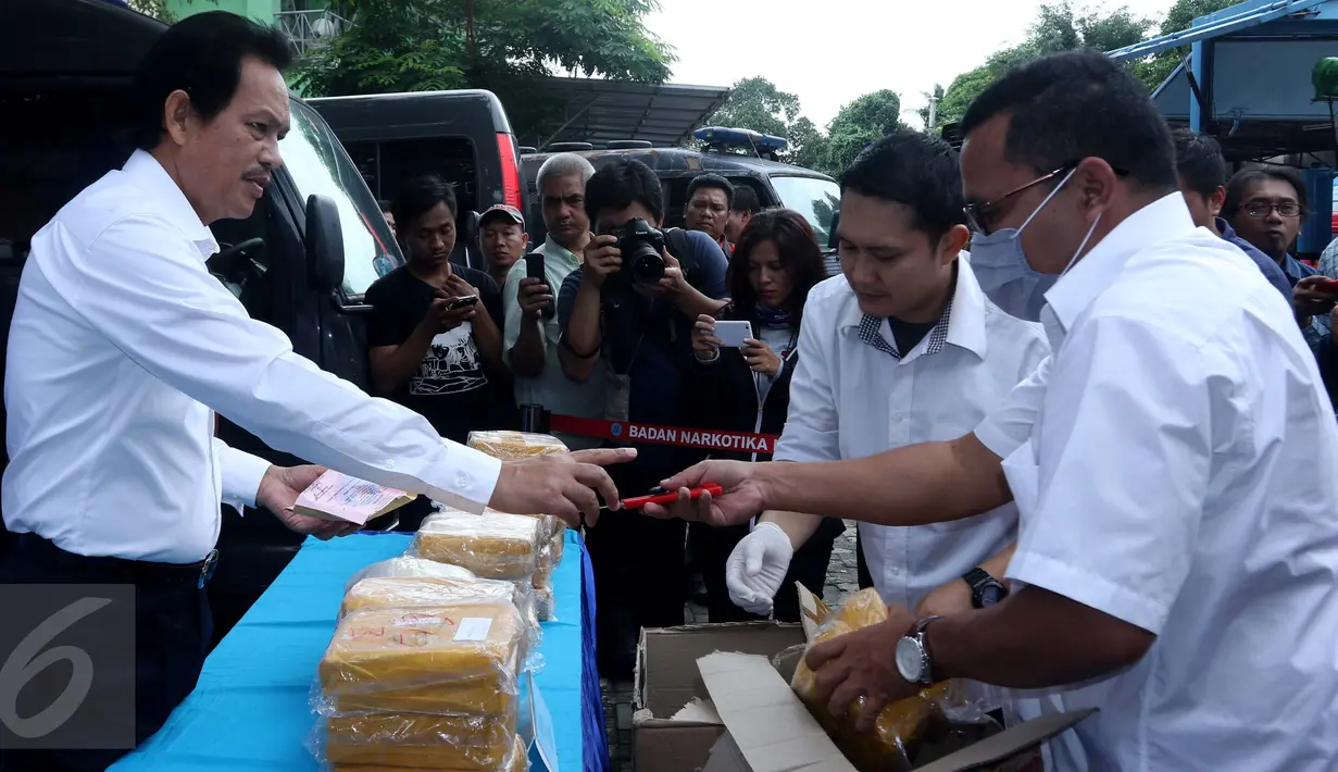 Petugas membuka barang bukti sabu jelang pemusnahan narkotika jenis sabu di lapangan parkir BNN, Jakarta, Senin (24/10). Sebanyak 32.710,50 gram atau 32 kg sabu yang berasal dari jaringan Medan berhasil dimusnahkan. (Liputan6.com/Gempur M Surya)