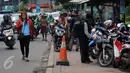 Warga melintas di samping trotoar yang dijadikan tempat parkir motor di Jalan Juanda, Bekasi, 4 Oktober 2016. Trotoar yang seharusnya untuk pejalan kaki ini dialih fungsikan oleh jasa parkir liar sebagai tempat parkir kendaraan bermotor. (Foto: Fajar)