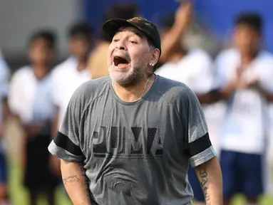 Legenda sepak bola, Diego Maradona, memberikan pelatihan kepada anak-anak di Barasat, Selasa (12/12/2017). Kunjungan ini dilakukan pria asal Argentina itu dalam rangkaian liburan. (AFP/Dibyangshu Sarkar)