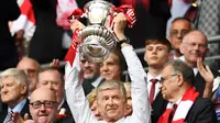 Pelatih Arsenal, Arsene Wenger, mengangkat trofi usai menjuarai final Piala FA melawan Chelsea di Stadion Wembley, Sabtu (27/5/2017). Arsenal menang 2-1. (EPA/Andy Rain)