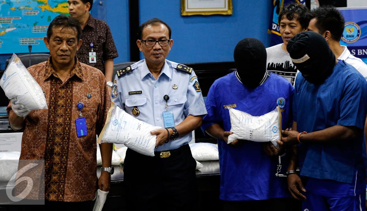 Deputi BNN, Deddy Fauzi El Hakim (kiri) menunjukan barang bukti sabu di Jakarta, Jumat (28/8/2015). BNN berhasil membongkar penyelundupan sabu seberat 103,8 kilogram yang dimasukkan ke dalam mesin sepeda motor dan alat pijat. (Liputan6.com/Yoppy Renato)