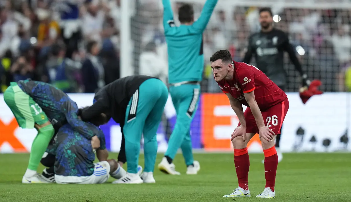 Pemain Liverpool Andrew Robertson (kanan) sedih ketika para pemain Real Madrid merayakan kemenangan mereka pada pertandingan sepak bola final Liga Champions di Stade de France, Saint Denis, Prancis, 28 Mei 2022. Real Madrid menang 1-0. (AP Photo/Petr David Josek)