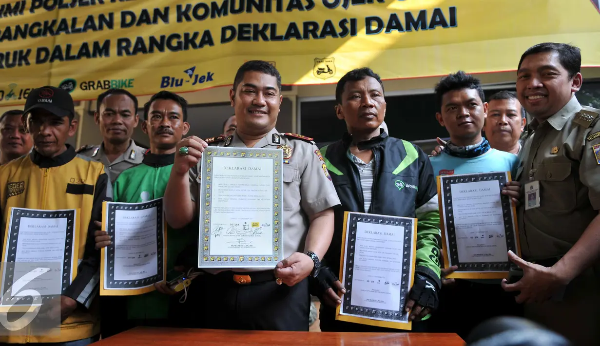 Petugas kepolisian bersama pengemudi ojek online dan ojek pangkalan memperlihatkan deklarasi damai komunitas ojek pangkalan dengan komunitas ojek online di Polsek Kebun Jeruk, Jakarta (22/9/2015). (Liputan6.com/Gempur M Surya)