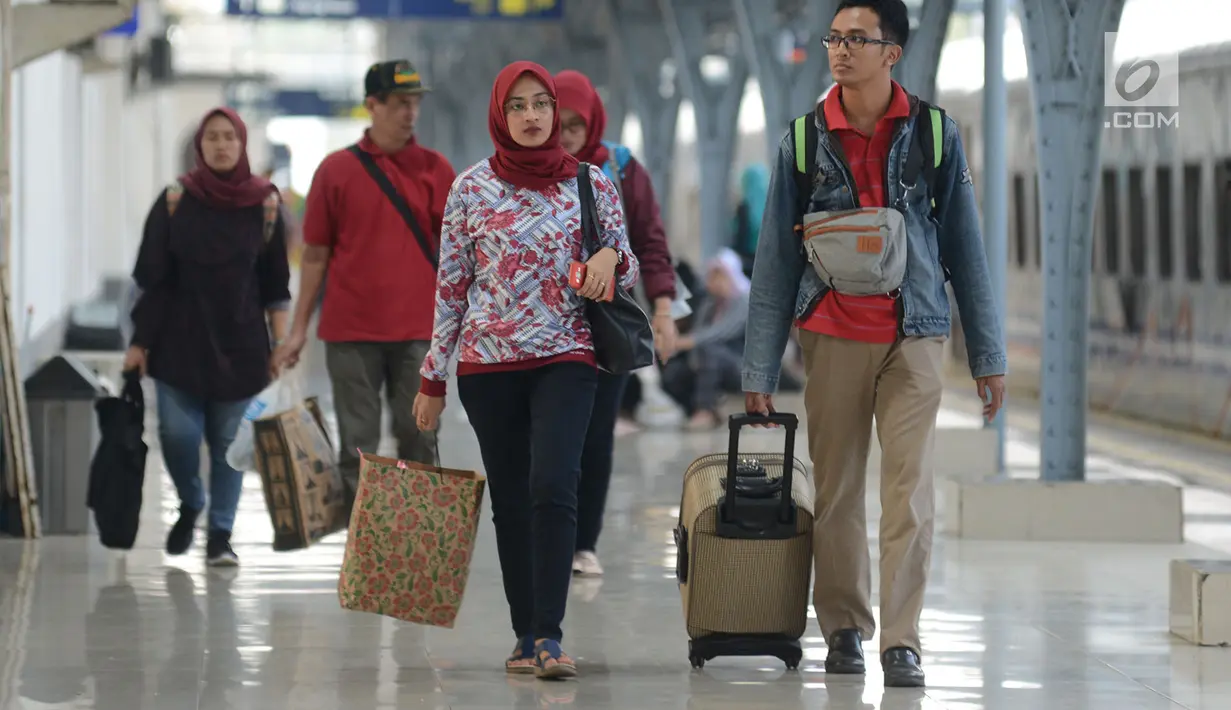 Pemudik berjalan menuju pintu kedatangan di Stasiun Pasar Senen, Jakarta, Sabtu (8/6/2019). Volume penumpang arus balik melalui moda transportasi kereta api  di stasiun Stasiun Senen mengalami lonjakan pada H+3 Lebaran. (merdeka.com/Imam Buhori)