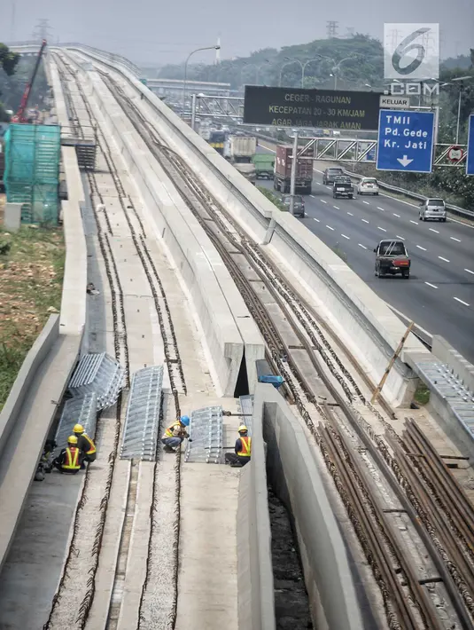 Pekerja menyelesaikan pembangunan proyek kereta api ringan (light rail transit/LRT) di kawasan Kampung Makasar, Jakarta, Kamis (26/7). Secara keseluruhan, proyek kereta ringan atau LRT Jakarta telah rampung sekitar 85 persen. (Liputan6.com/Faizal Fanani)