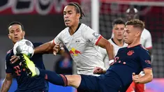 Gelandang Bayern Munchen, Joshua Kimmich, berebut bola dengan striker RB Leipzig, Yussuf Poulsen, pada laga Bundesliga 2019/20 di Leipzig, Sabtu (14/9). Kedua klub bermain imbang 1-1. (AFP/John Macdougall)