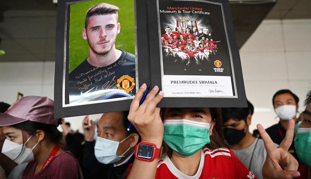 Penggemar Manchester United Football Club asal Thailand menyambut kedatangan skuad Setan Merah, Sabtu (9/7/2022) di bandara Bangkok, Thailand. (AFP/Manan Vatsyayana)