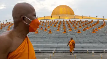 Biksu Buddha menghadiri perayaan Makha Bucha di kuil Wat Dhammakaya di provinsi Pathum Thani, utara Bangkok (16/2/2022). Makha Bucha merupakan salah satu hari raya terpenting bagi para penganut agama Buddha. (AFP/Jack Taylor)