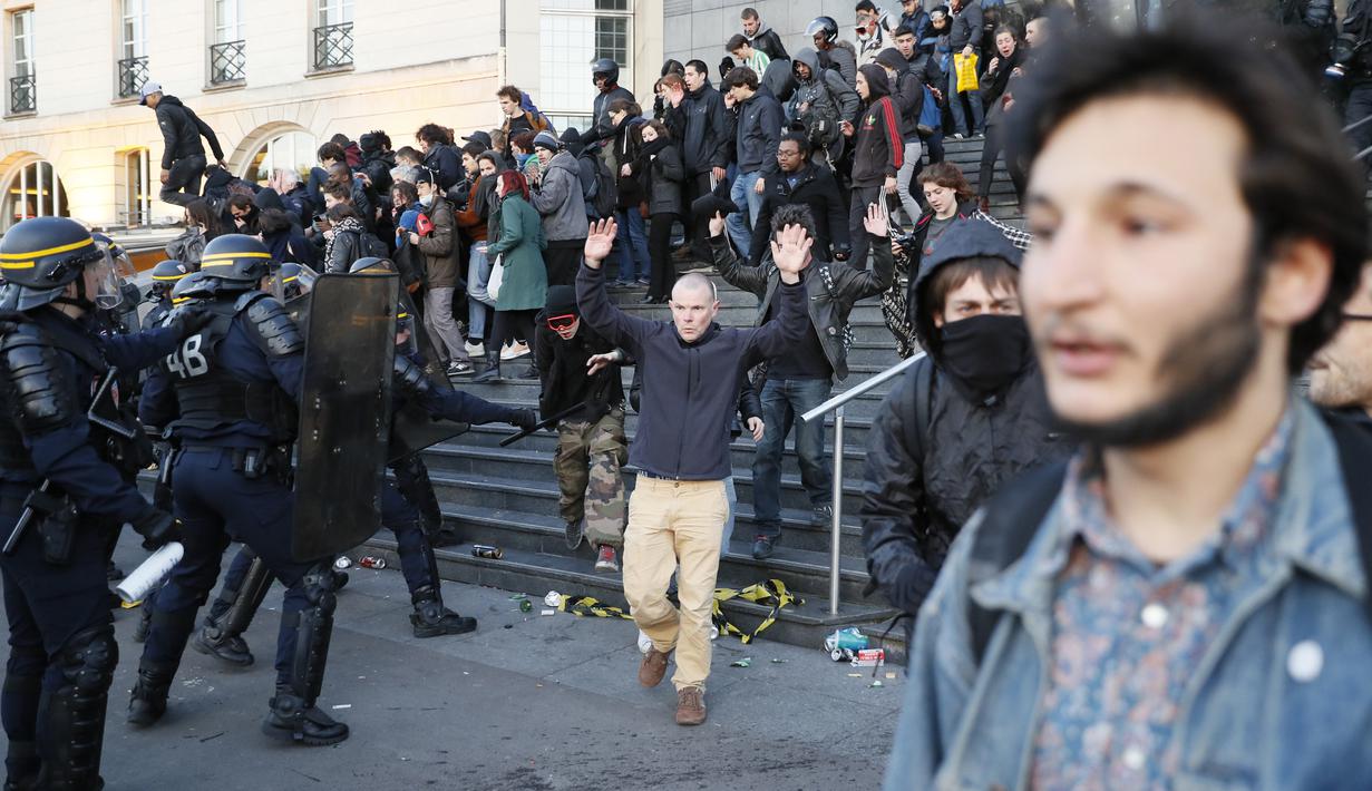 Pasukan anti-huru hara berusaha membubarkan demonstran yang menggelar aksinya usai pengumuman hasil putaran pertama pemilihan Presiden di Paris (23/4). (AFP/Thomas Samson)
