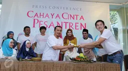 Ustadz Yusuf Mansur menerima potongan tumpeng saat menggelar konferensi pers film Cahaya Cinta pesantren, Jakarta, Senin (25/1/2016). Film ini diadaptasi dari novel karya Ira Madan. (Liputan6.com/Herman Zakharia)