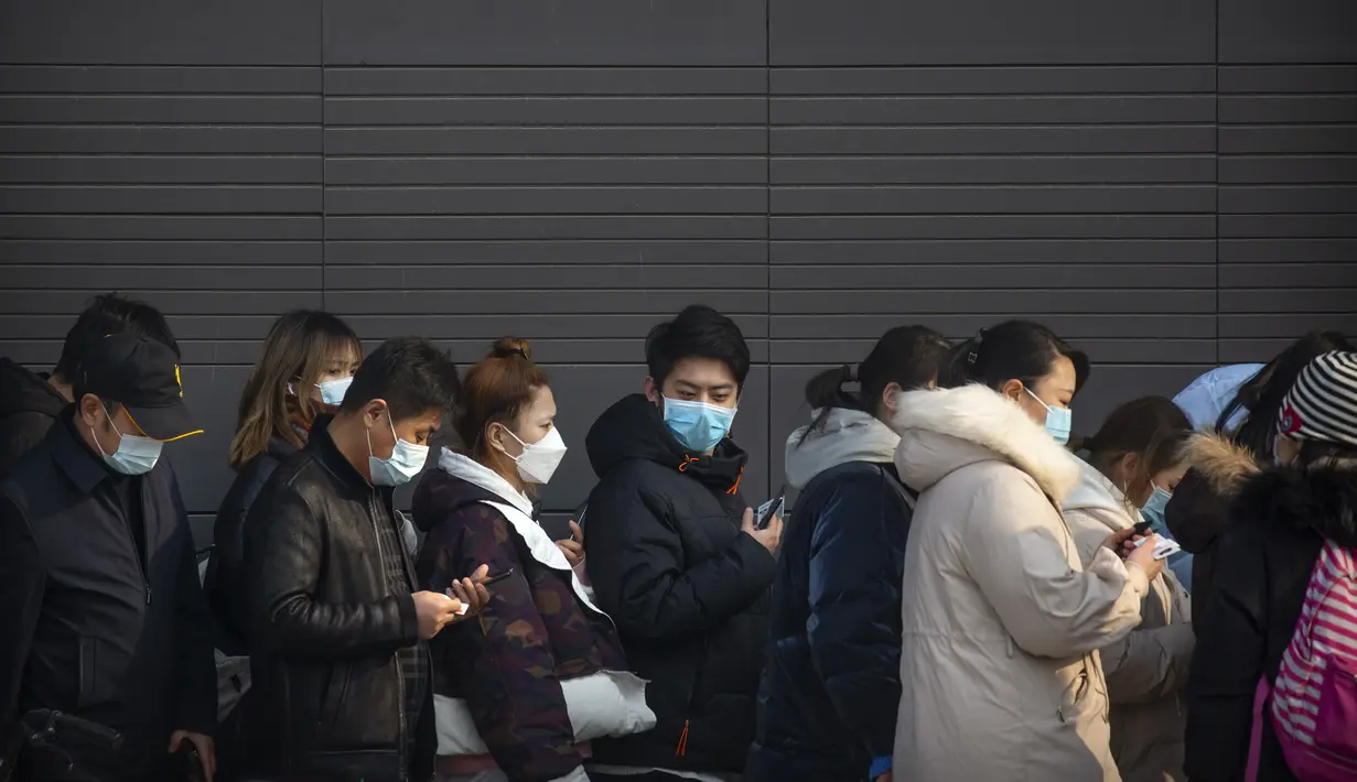 Orang-orang yang memakai masker pelindung berbaris untuk pengujian massal COVID-19 di Beijing, China, Jumat (22/1/2021). Beijing memerintahkan pengujian COVID-19 untuk sekitar dua juta orang menyusul kasus baru. (AP Photo/Mark Schiefelbein)