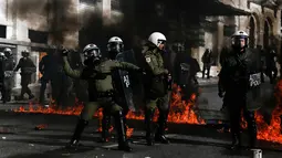 Sejumlah polisi anti huru-hara melawan aksi demonstran yang melemparkan bom api di Athena, Yunani, (12/11/2015). Demonstran melempari para polisi dengan bom api. (REUTERS/Alkis Konstantinidis)