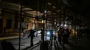Ketegangan yang terjadi antara Amerika Serikat (AS)-Israel dengan Iran cukup memberikan pengaruh kuat bagi perekonomian Mesir, terlebih imbas dari penutupan jalur perdagangan di Selat Hormuz. Tampak dalam foto, orang-orang berjalan melewati toko-toko yang tutup lebih awal karena jam malam yang diberlakukan pemerintah untuk mengurangi biaya energi di pusat kota Kairo, Mesir, pada Kamis 2 April 2026. (Khaled DESOUKI/AFP