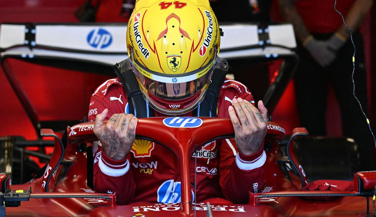 Pembalap Ferrari, Lewis Hamilton masuk ke kokpit mobilnya dalam sesi latihan bebas Formula 1 GP Australia 2025 di Sirkuit Albert Park, Melbourne, Australia pada Jumat (14/03/2025). (AFP/Saeed Khan)