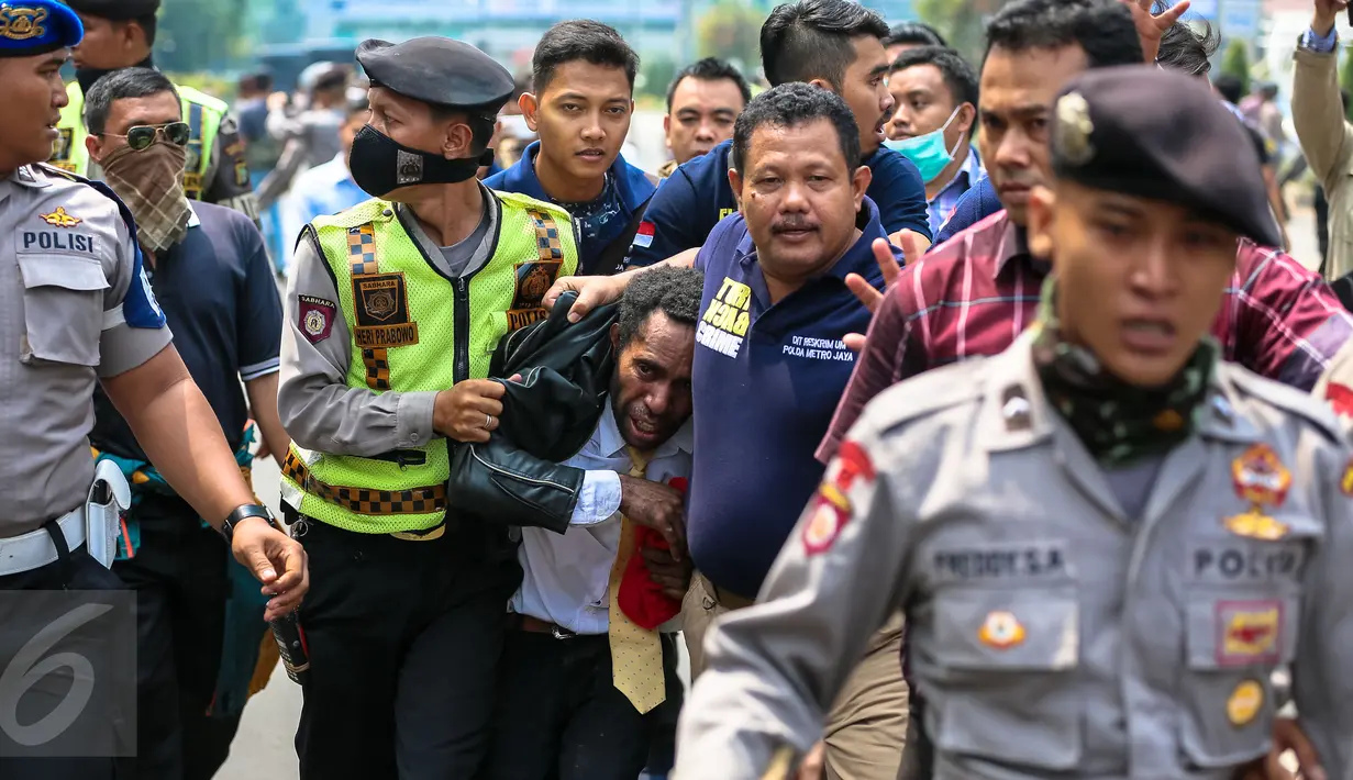 Petugas mengamankan pengujuk rasa saat aksi memperingati 1 Desember yang diartikan sebagai hari kemerdekaan Papua di Bundaran HI, Jakarta, Selasa (1/12). Aksi itu diikuti ratusan orang Papua yang berdomisili di Jawa dan Bali. (Liputan6.com/Faizal Fanani)