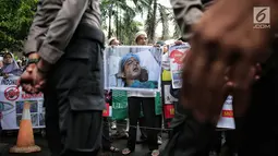 Massa membawa gambar warga Kashmr yang menjadi korban kekerasan dalam aksi solidaritas di depan Kedubes India, Jakarta, Rabu (6/2). Massa meminta pemerintah India segera menghentikan genosida yang dilakukan oleh militer. (Liputan6.com/Faizal Fanani)