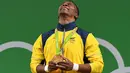 Atlet angkat besi Kolombia, Oscar Figueroa menitikkan air mata setelah sukses merebut medali emas terakhir sebelum pensiun dari cabang olahraga angkat besi di kelas 62 kg di Olimpiade Rio 2016, 8 Agustus 2016. (AFP PHOTO/GOH Chai Hin)
