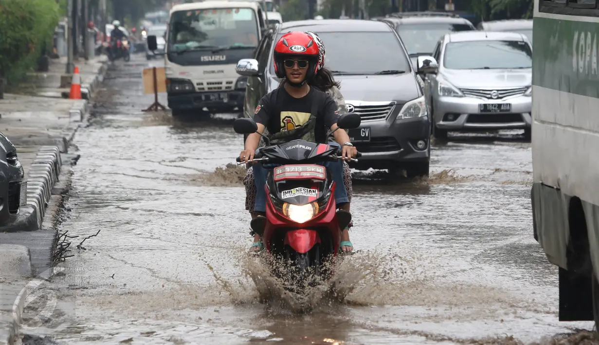 Pengendara motor mencoba menerobos genangan air di Jalan Cikini Raya, Jakarta, Sabtu (7/11). Meski baru pertama kali diguyur hujan selama musim kemarau, jalan tersebut langsung terendam air. (Liputan6.com/ Immanuel Antonius)