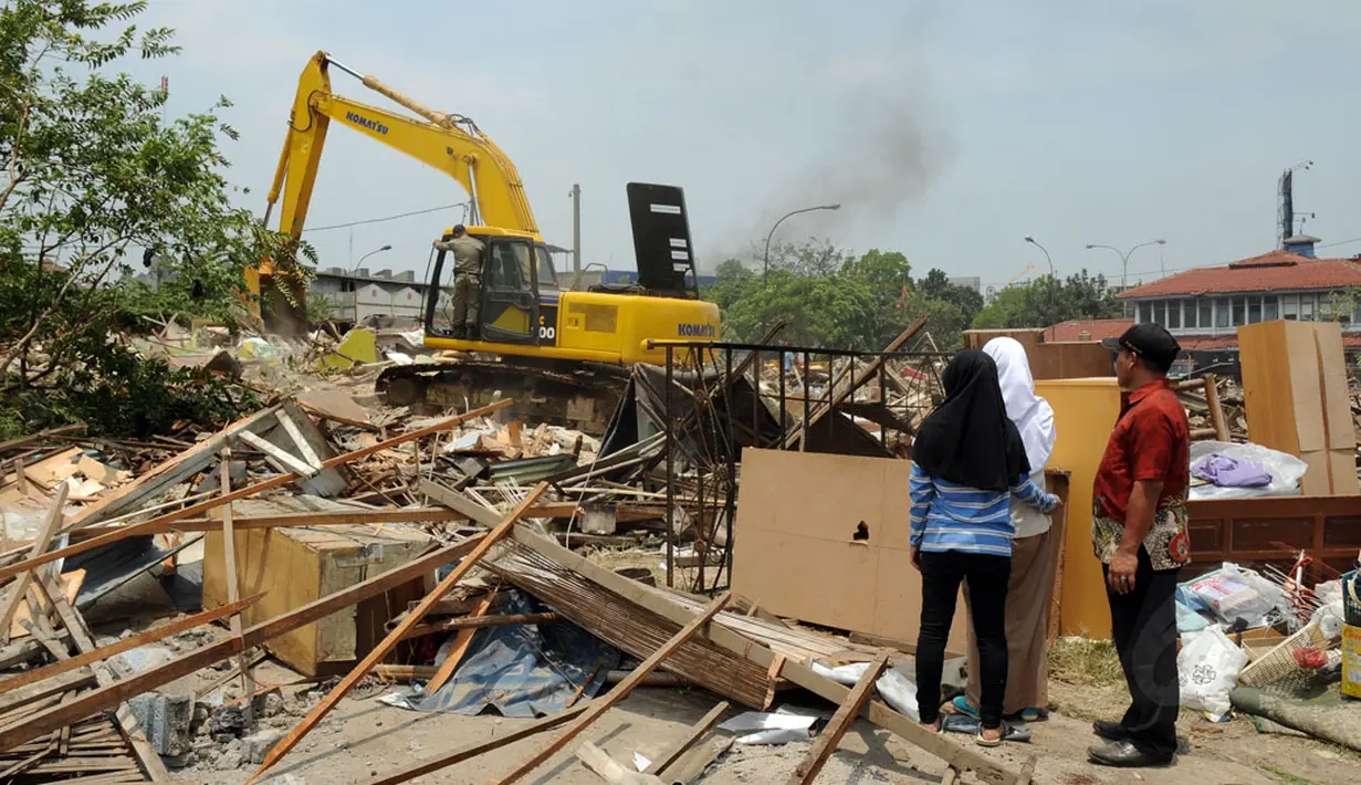 Sejumlah orang menyaksikan proses pembongkaran ratusan kios di Terminal Depok, Jawa Barat, (8/10/2014). Sebanyak 150 bangunan kios dan 80 lapak PKL ditertibkan guna pembangunan Terminal Terpadu Kota Depok, Jawa Barat. (Liputan6.com/Helmi Fithriansyah)