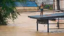 Diketahui, Thailand secara rutin mencatat bahwa hujan lebat biasanya terjadi sejak Juni hingga September. Tampak dalam foto, seorang pria bereaksi saat berdiri di atas atap di samping banjir bandang yang tinggi di Hat Yai, Provinsi Songkhla, Thailand selatan, pada 26 November 2025. (Arnun Chonmahatrakool/THAI NEWS PIX/AFP)