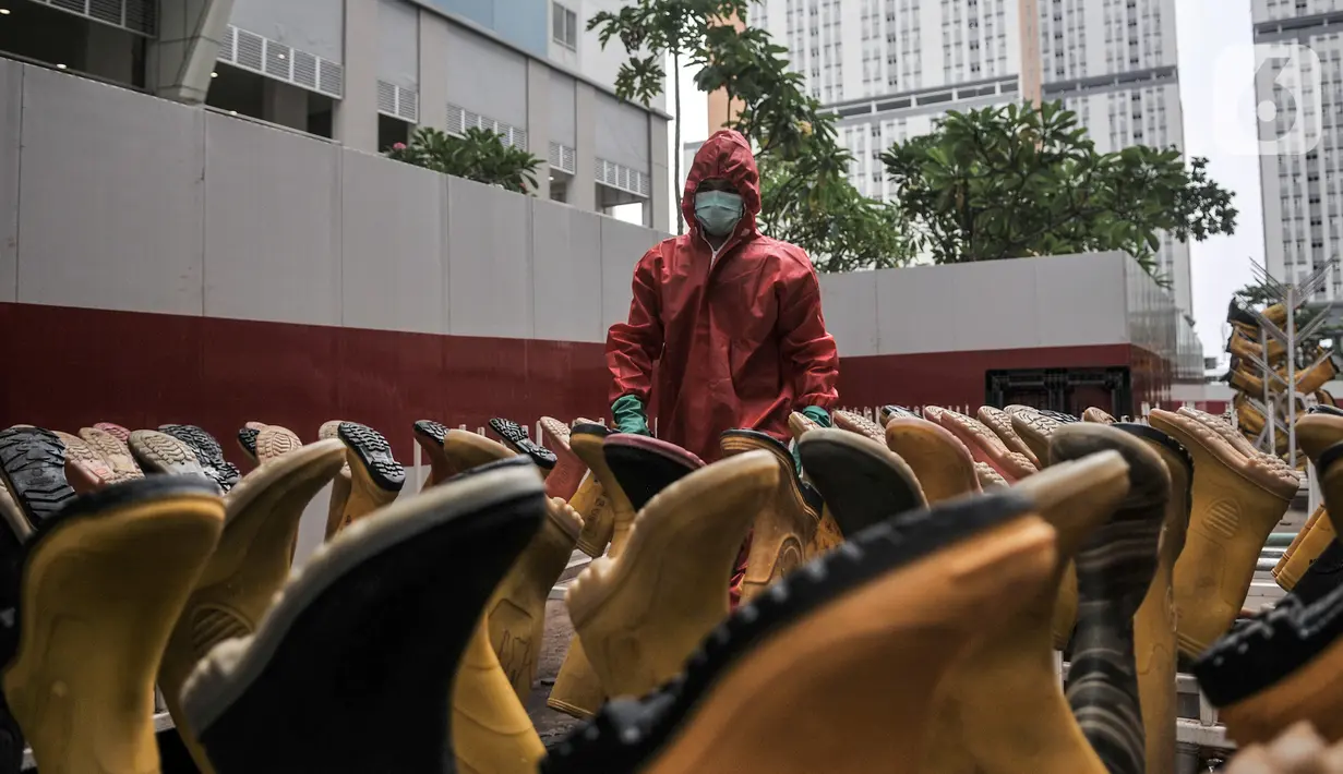 Tim Sterilisasi menjemur sepatu yang digunakan tenaga kesehatan di Rumah Sakit Darurat (RSD) Wisma Atlet Kemayoran, Jakarta. Dalam sehari Tim Sterilisasi mampu mencuci hingga 300 pasang sepatu yang telah digunakan tenaga kesehatan yang bertugas menangani pasien Covid-19. (merdeka.com/Iqbal Nugroho)