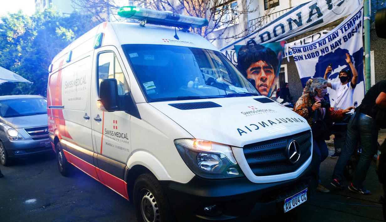 Mobil ambulans yang membawa Diego Maradona melintas di depan fans di La Plata, Argentina, Selasa (3/11/2020). Sejumlah fans Argentina berkumpul di depan rumah sakit untuk memberi dukungan kepada sang legenda. (AP/Natacha Pisarenko)