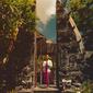 Mempelajari budaya Bali saat di sana, pesona Agnez Mo ketika mengenakan busana adat Bali mencuri perhatian saat berpose di gapura. Ia mengenakan kebaya renda warna putih yang dipadukan dengan jarit warna ungu. (Liputan6.com/IG/@agnezmo)