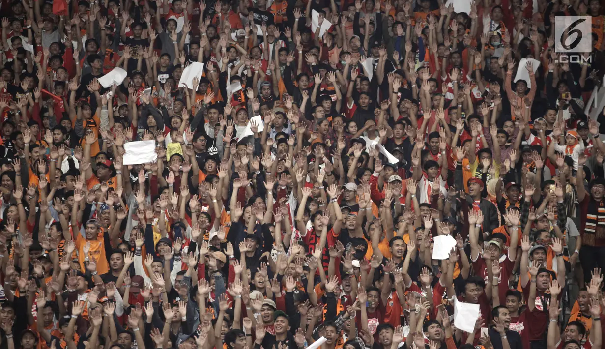 Ribuan suporter Persija Jakarta, The Jakmania mengangkat tangan sambil yel-yel pada laga final Piala Presiden 2018 antara Persija Jakarta melawan Bali United di Stadion Utama GBK, Senayan, Jakarta, Sabtu (17/2). (Liputan6.com/Arya Manggala)