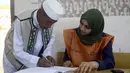 Sebelum masuk ke bilik suara, warga Libya diwajibkan melakukan pendaftaran di Tempat Pemungutan Suara. Tampak salah satu warga Libya sedang melakukan pendaftaran di sebuah TPS di Benghazi, (25/6/2014). (REUTERS/Esam Omran Al-Fetori)