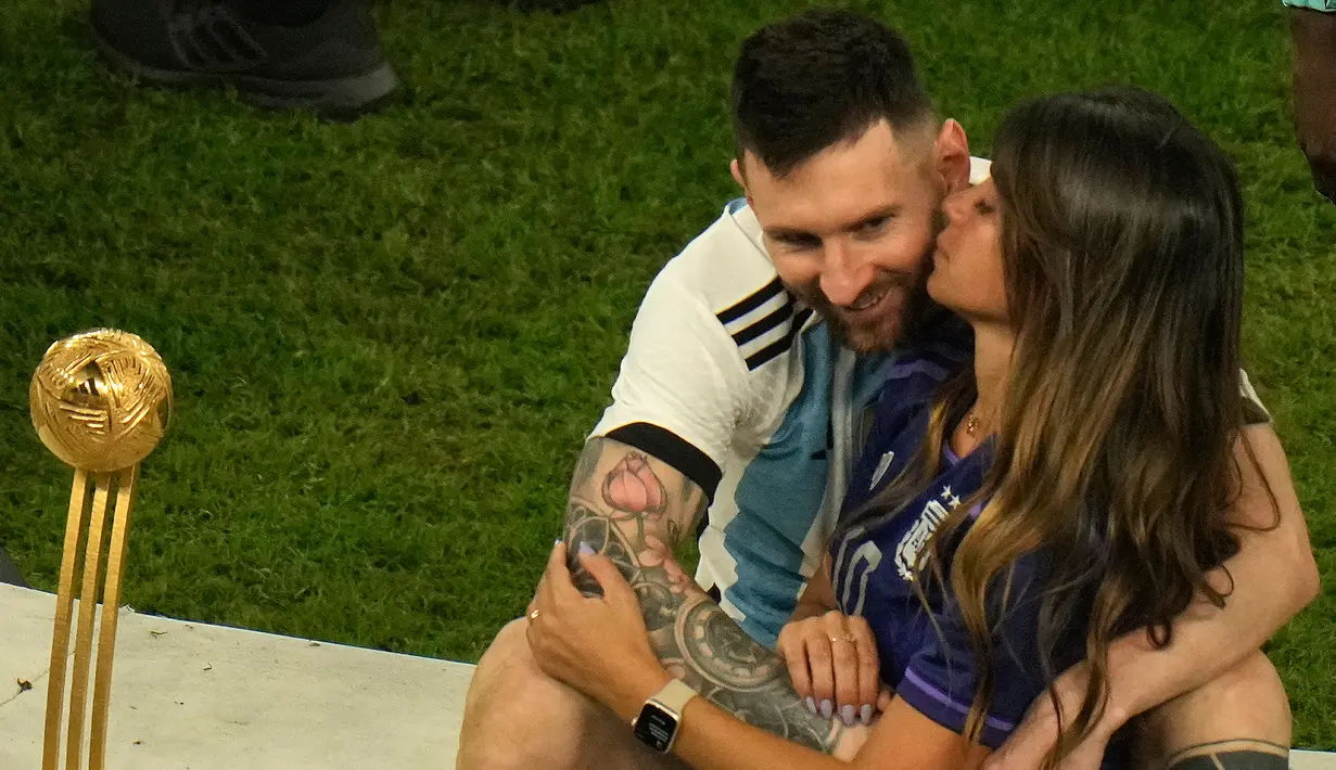 Pemain Argentina Lionel Messi dicium istrinya Antonela Roccuzzo usai mengalahkan Prancis pada pertandingan sepak bola final Piala Dunia 2022 di Stadion Lusail, Lusail, Qatar, 18 Desember 2022. Argentina menang 4-2 atas Prancis melalui drama adu penalti setelah pertandingan berakhir imbang 3-3. (AP Photo/Francisco Seco)