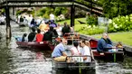 Wisatawan menaiki perahu menyusuri sungai di Giethoorn yang menjadi tujuan wisata favorit di Belanda pada 6 Agustus 2019. Mendapat julukan 'Venice of the North', kota tersebut menggunakan kanal-kanal sebagai jalan dan lalu lalang transportasi sehari-hari. (Robin van Lonkhuijsen/ANP/AFP)