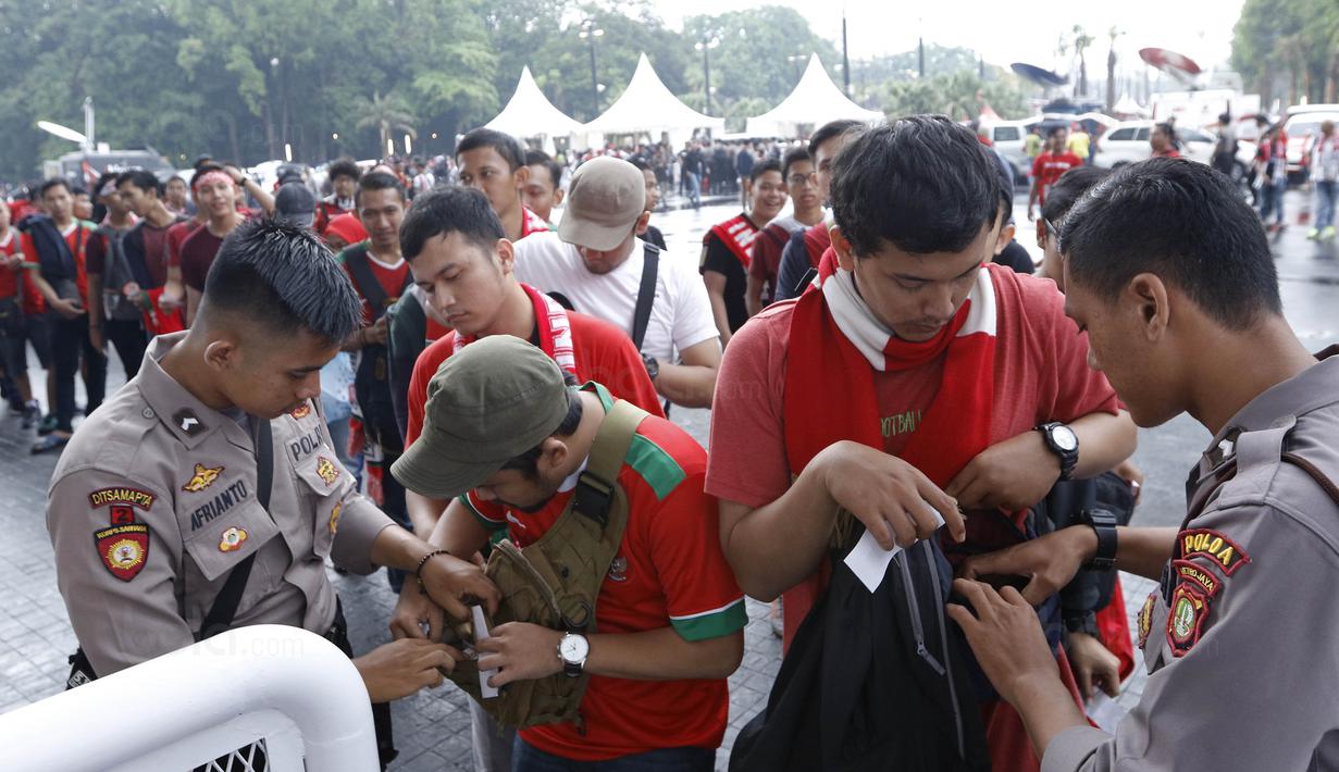 Polisi memeriksa suporter sebelum memasuki SUGBK, Senayan, Jakarta, Minggu (14/1/2018). Fasilitas baru tersebut untuk meningkatkan keamananan, kenyamanan serta kedisiplinan suporter. (Bola.com/M Iqbal Ichsan)