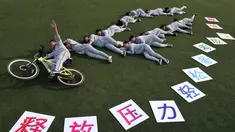 Sejumlah siswa berpose di rumput membuat slogan ""release your stress, let your dream fly" sebelum mengikuti ujian masuk perguruan tinggi di sebuah sekolah di Handan, Provinsi Hebei China utara (24/5). (AFP PHOTO/STR)