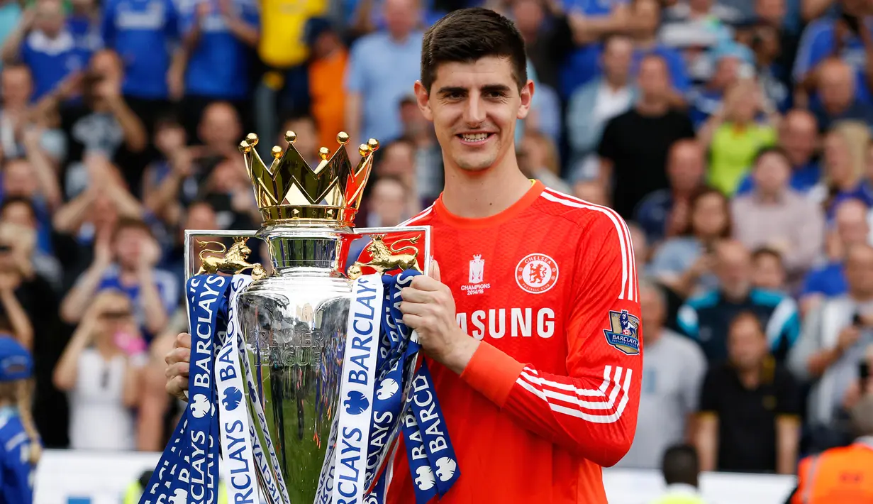 Kiper Chelsea, Thibaut Courtois tersenyum sambil membawa trofi Premier League di Stamford Bridge, Minggu (24/5/2015). Ini merupakan trofi pertama Thibaut Courtois di Premier League. (Reuters/John Sibley)