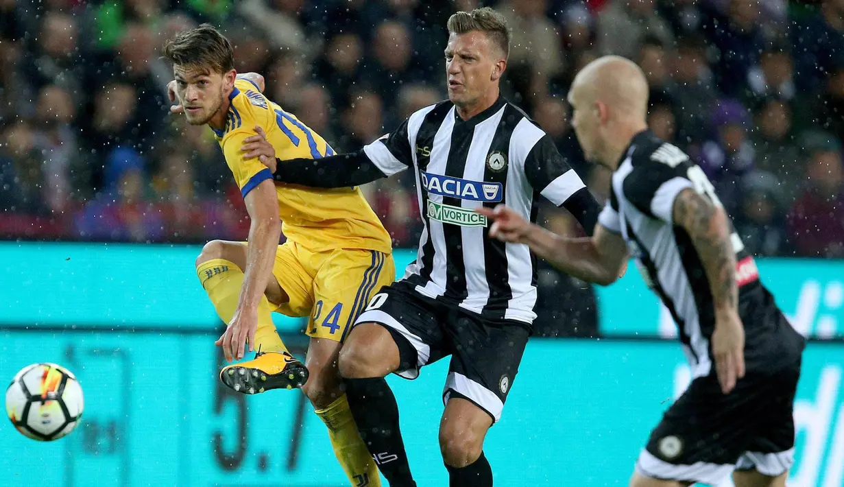 Bek Juventus, Daniele Rugani, membuang bola dari jangkauan striker Udinese, Maxi Lopez, pada laga Serie A Italia di Stadion Friuli, Udine, Minggu (22/10/2017). Udinese kalah 2-6 dari Juventus. (AP/Alberto Lancia)