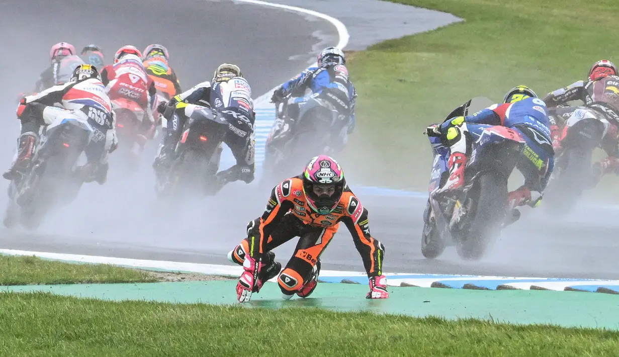Pembalap Beta Tools Speed Up, Alonso Lopez, terjatuh setelah mengalami kecelakaan diawal perlombaan Moto2 dalam MotoGP Australian 2023 yang berlangsung di Phillip Island, Minggu (22/10/2023). (AFP/Paul Crock)