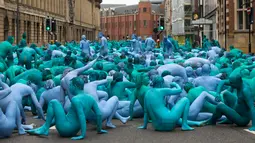 Ribuan orang tanpa busana di jalanan saat menjadi model sebuah seni berjudul "Sea of Hull" karya Spencer Tunick asal Amerika Serikat di pusat Kota Hull, Inggris, Sabtu (9/7). (AFP Photo/Jon Super)